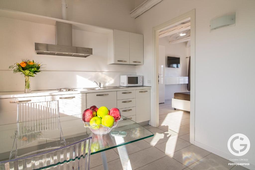 a kitchen with a glass table with a bowl of fruit at YPApartments FIERA in Padova