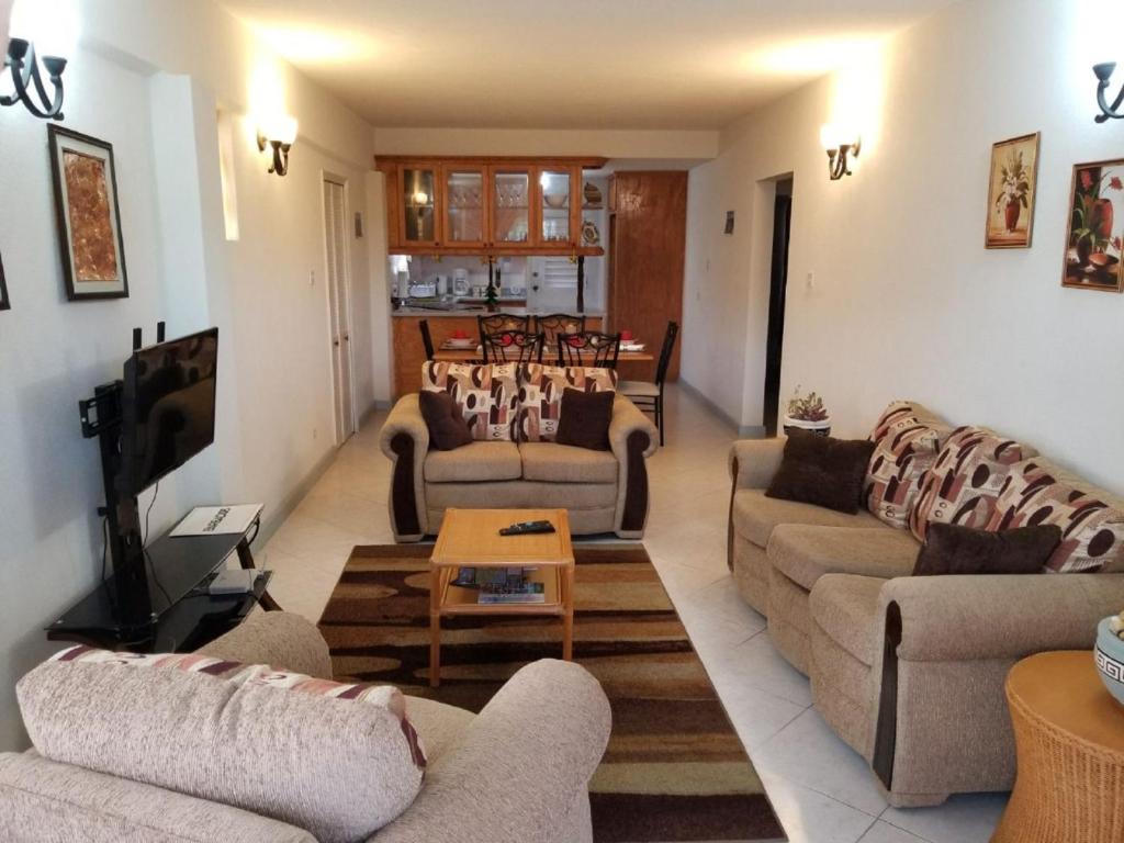 a living room with two couches and a tv at Breezy Apts in Saint Philip