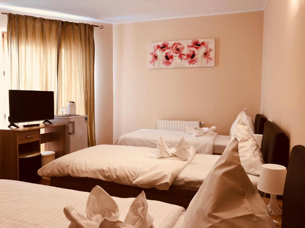 Habitación de hotel con 2 camas y TV en Monte Carlo Palace Rooms, en Bucarest