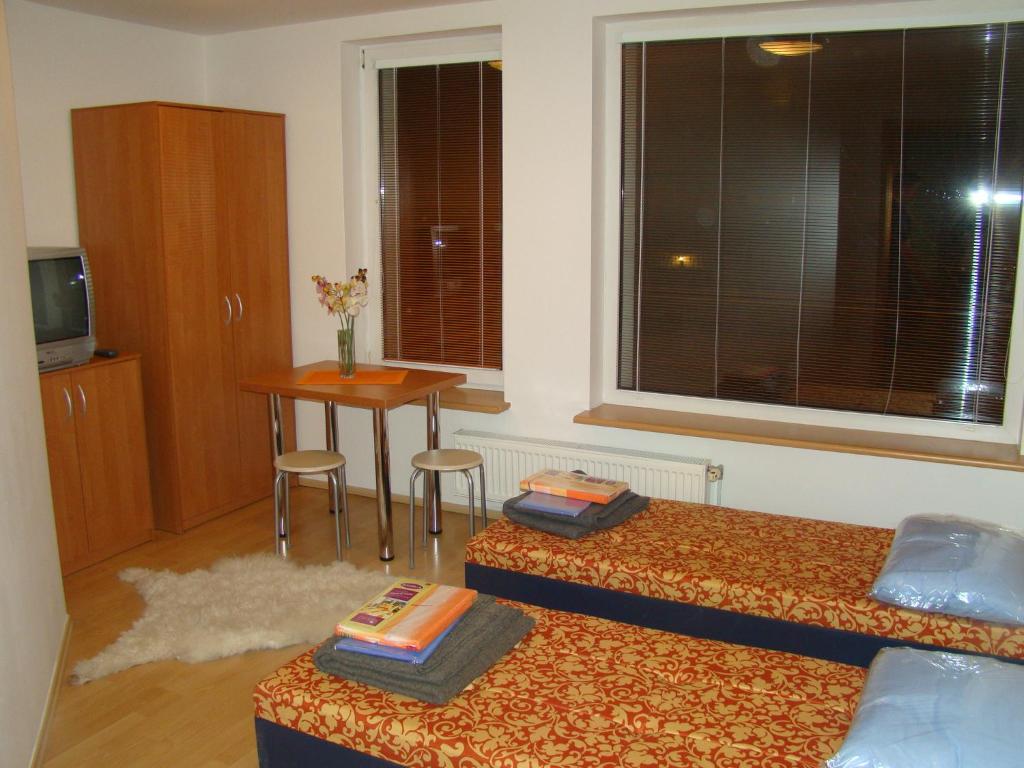 ワルシャワにあるAgatのベッド2台、テーブル、窓が備わる客室です。