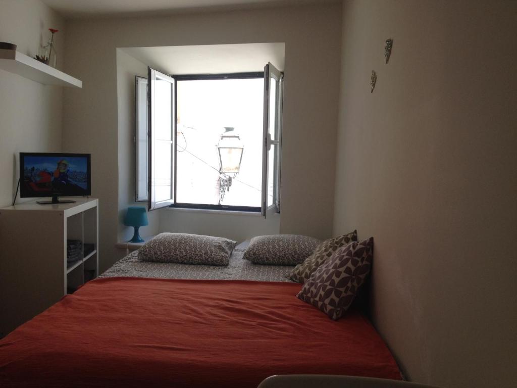 リスボンにあるLittle Alfama Townのベッドルーム1室(赤毛布、窓付)