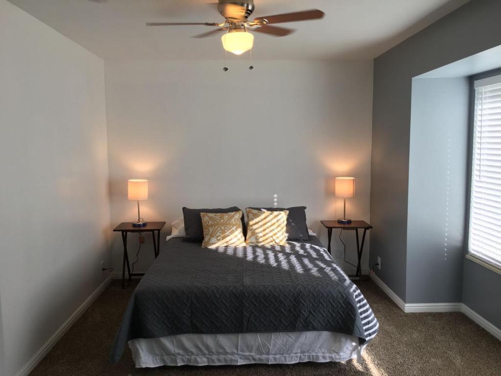 a bedroom with a bed with a ceiling fan and two side tables at Large Room Near UVU & BYU in Orem