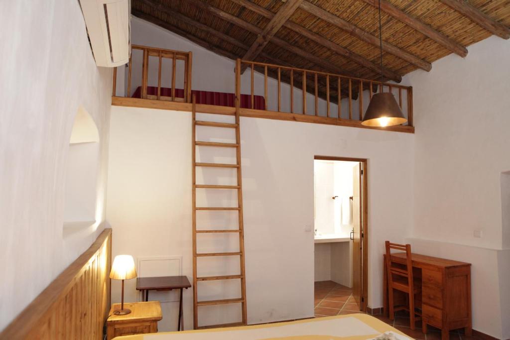 a room with a loft bed and a ladder at Casas do Palheiro Velho in Castro Marim