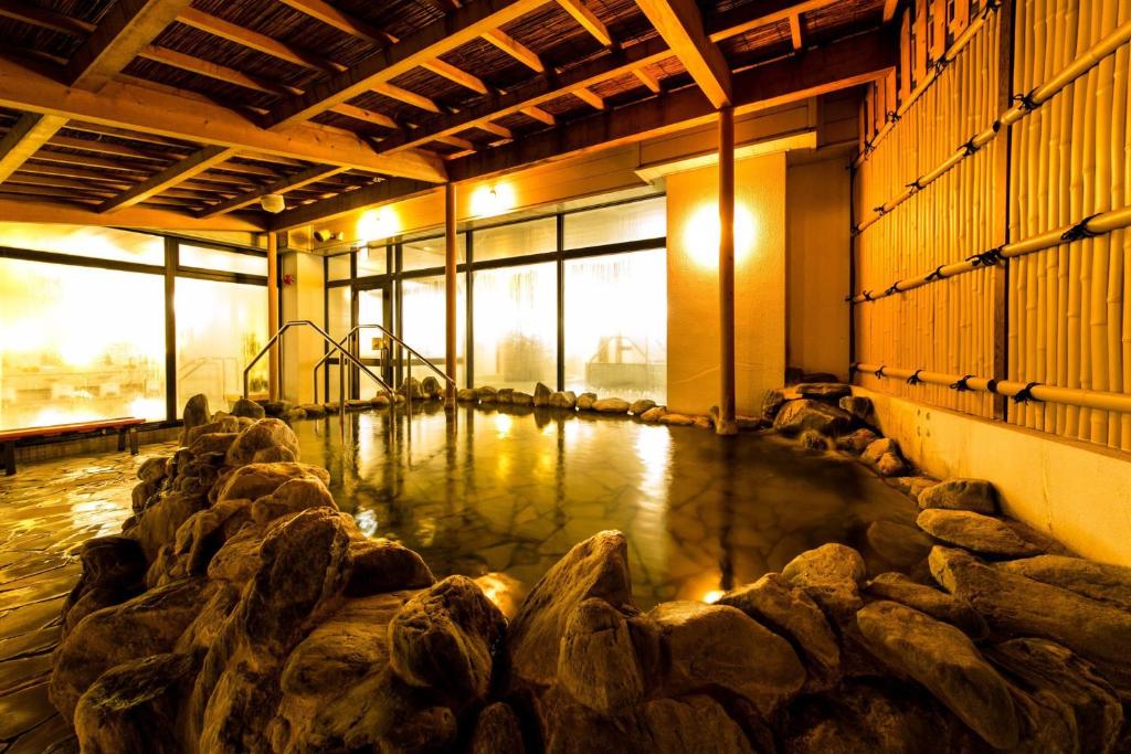 una stanza con una piscina di acqua salata con rocce di Aomori Center Hotel ad Aomori