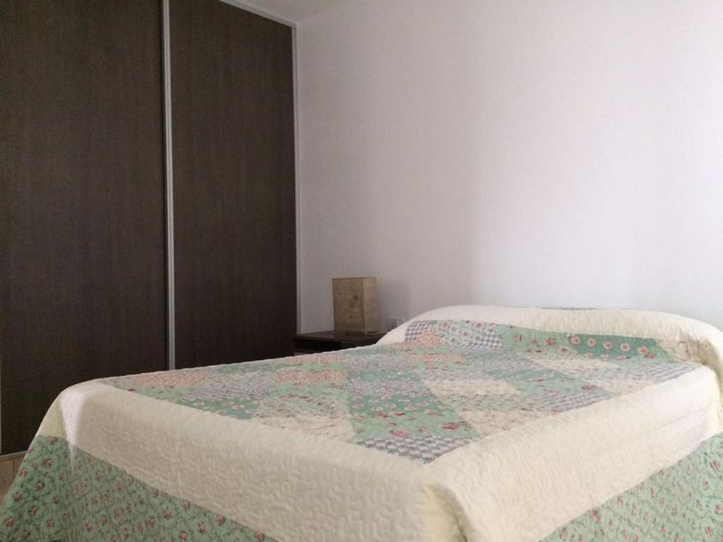 una camera da letto con un letto con una trapunta sopra di Altas Mareas a Las Grutas