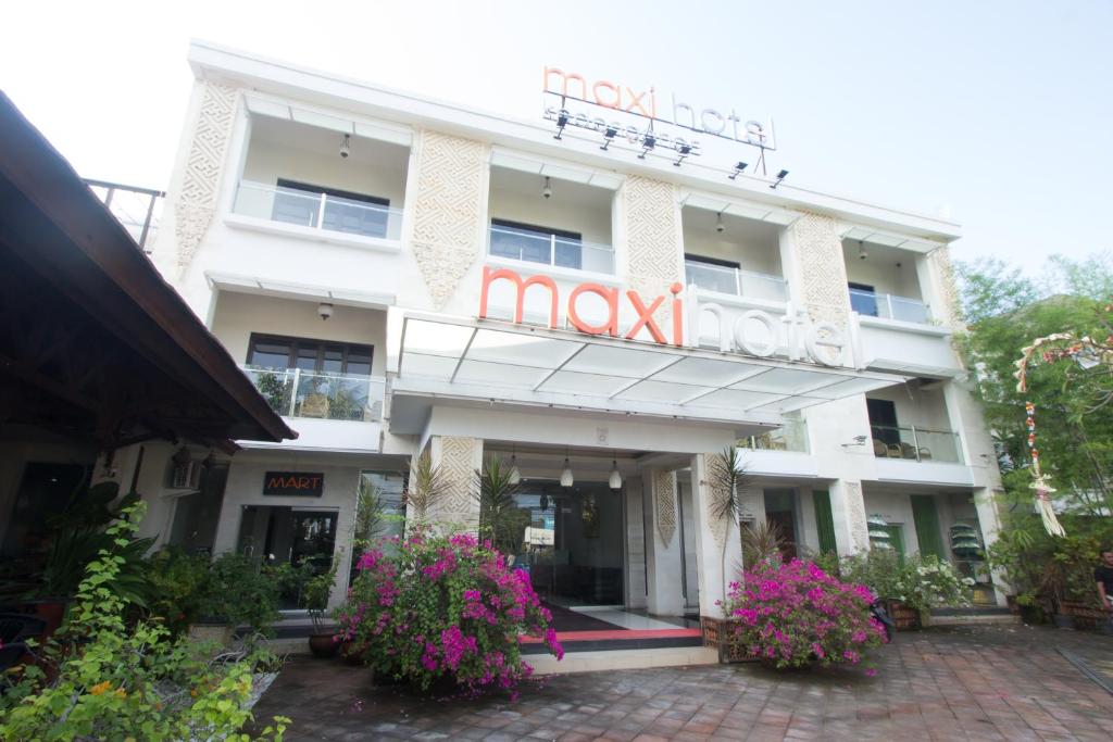 un edificio blanco con un cartel. en Maxi Hotel Kedonganan en Jimbaran