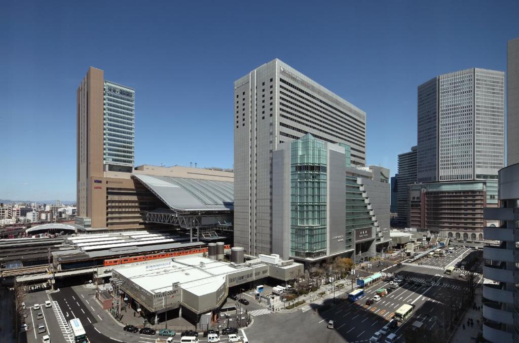 une ville avec de grands bâtiments et une rue avec des voitures dans l'établissement Hotel Granvia Osaka-JR Hotel Group, à Osaka