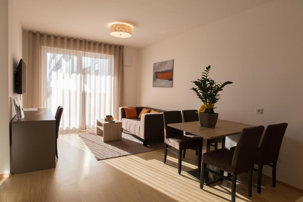 a living room with a table and chairs and a couch at Vitus Steyr Hotel & SPA Suites in Steyr