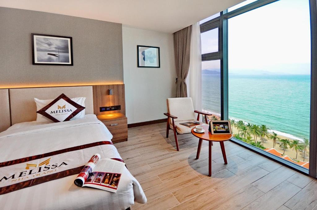 a hotel room with a bed and a view of the ocean at Melissa Hotel Nha Trang in Nha Trang