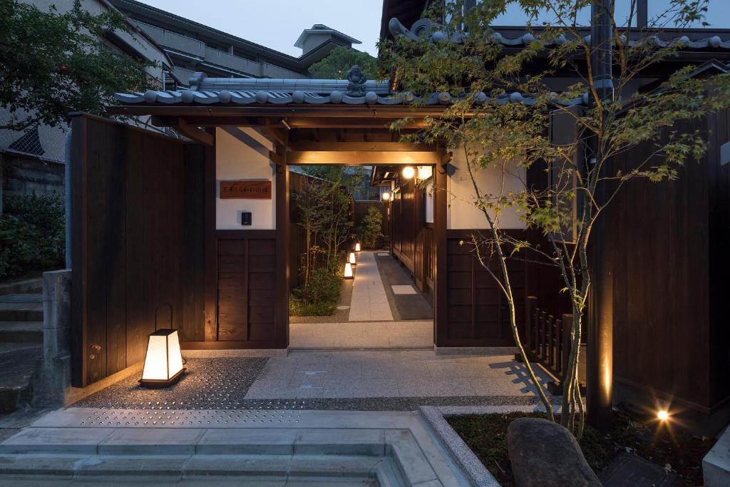 an entrance to a house with a gate and lights at THE MACHIYA VILLA Sanjo Shirakawa Koji in Kyoto