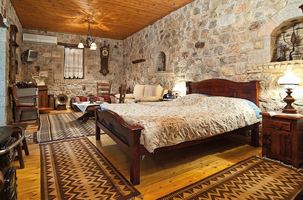 a bedroom with a bed and a stone wall at Alexandros Pension in Delphi