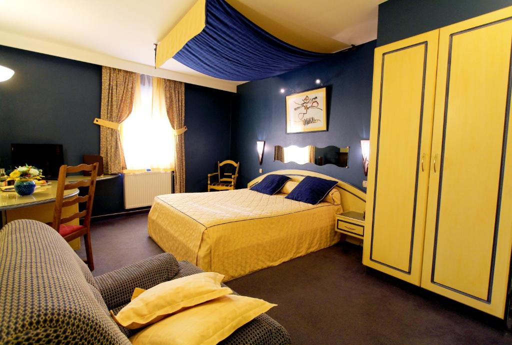 a hotel room with a bed and a couch at Les Reflets Jaunes in Givet