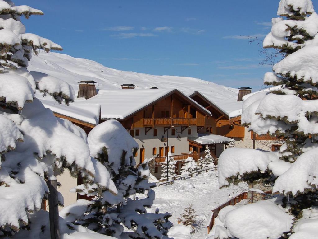 un lodge dans la neige avec des arbres enneigés dans l'établissement Le Hameau de la Sapinière, aux Menuires
