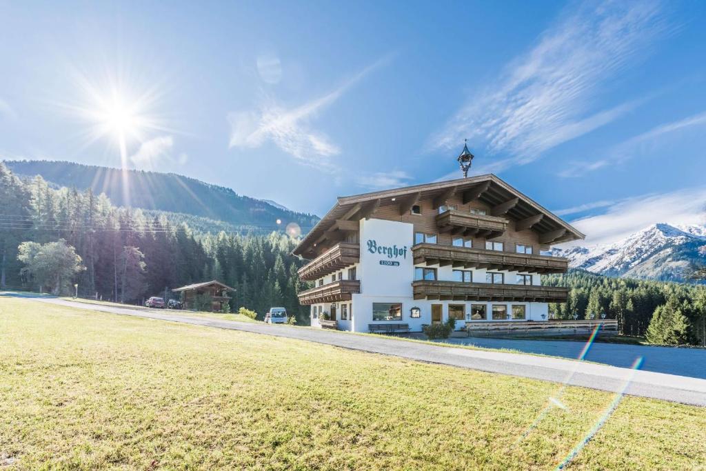 a building in the mountains with a grass field at Almliesl HOLL-556 in Hollersbach im Pinzgau