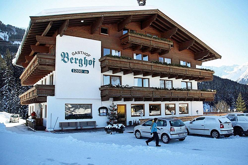 a man walking in front of a building in the snow at Almliesl HOLL-556 in Hollersbach im Pinzgau