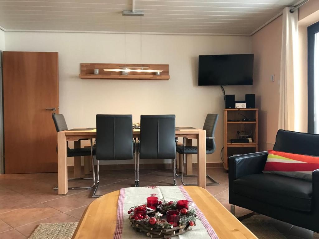 a living room with a table and chairs and a tv at Winterbergappartementen 27-10 in Winterberg