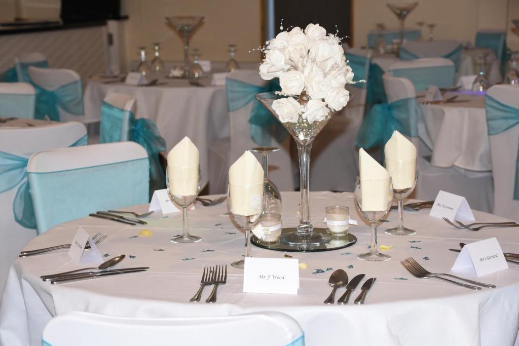 a table with white flowers in a vase on it at Warrens Village Motel and Self Catering in Clevedon