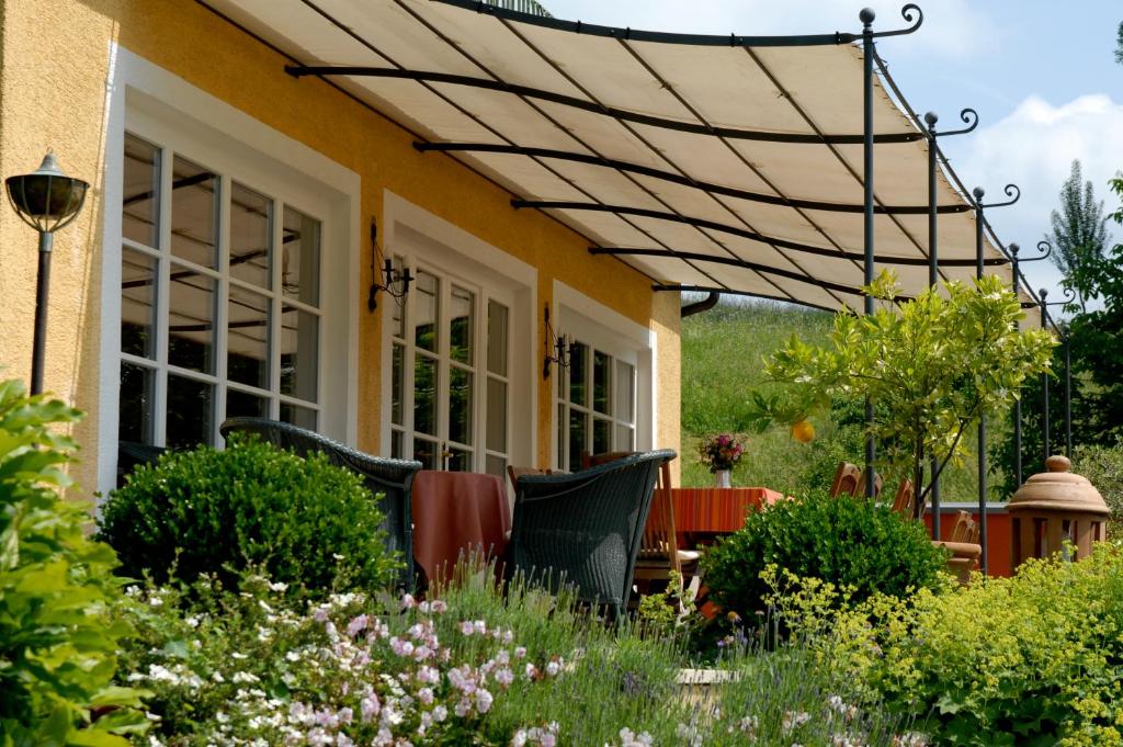 ein Haus mit einer Pergola im Garten in der Unterkunft Weingut Tauss in Leutschach