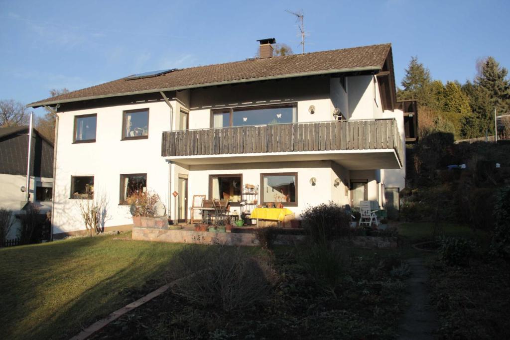 a large white house with a deck on a yard at Ferienwohnung Klimek in Michelstadt