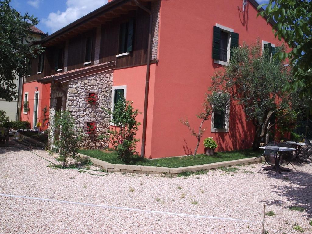 um edifício vermelho com árvores em frente em Agriturismo Corte Carolina em Verona