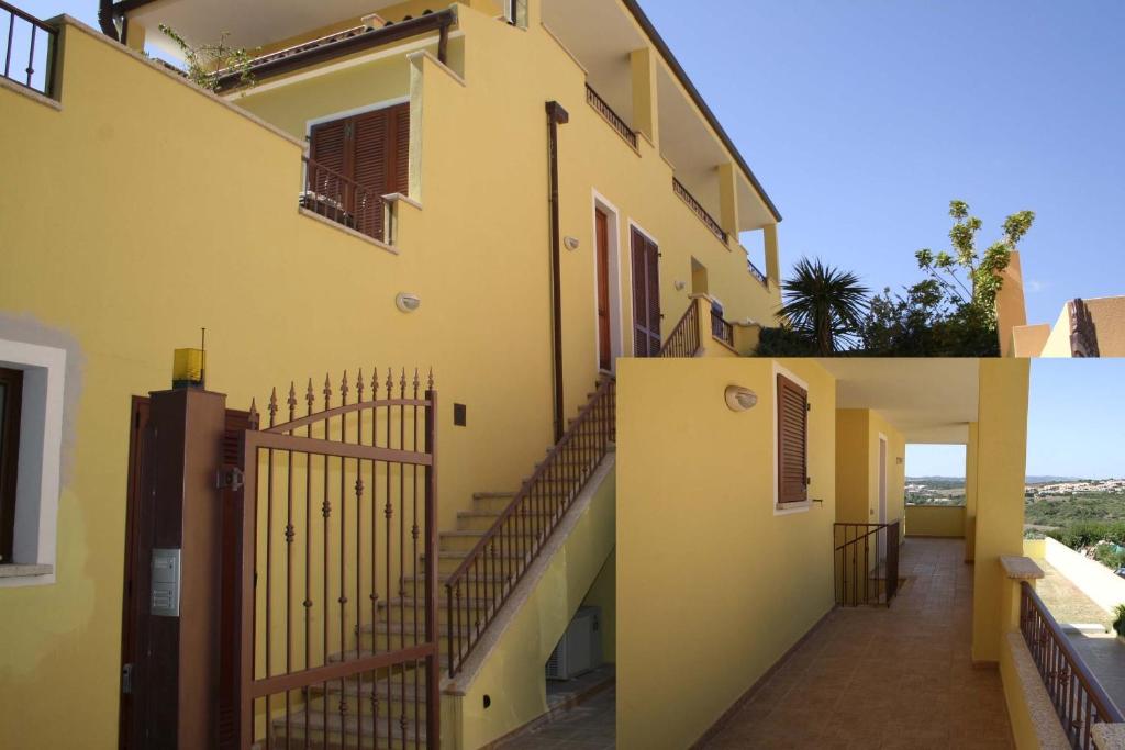 un edificio amarillo con escaleras a un lado en Appartamenti Galatea, en Palau