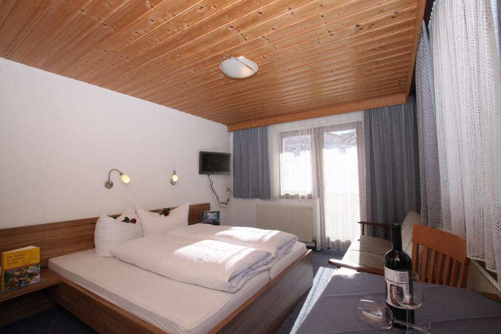ナウダースにあるAppartementhaus Salzgeberの木製の天井のベッドルーム1室(ベッド1台付)