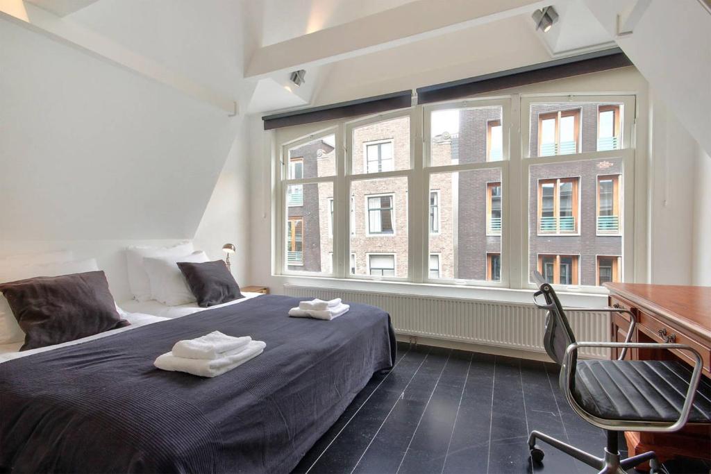 アムステルダムにある2 BEDROOM CITY CENTER TERRACEのベッドルーム1室(ベッド1台、大きな窓付)