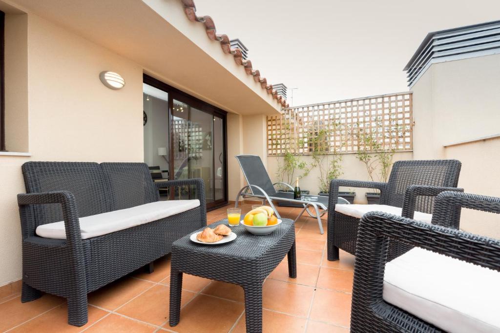 a patio with chairs and a table with a bowl of fruit at Matarolux 1 in Mataró