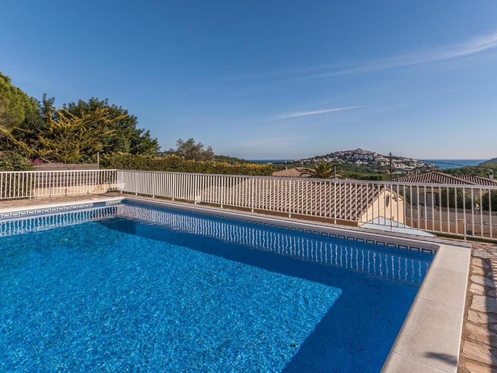 レスカラにあるSpacious Holiday Home in L Escala with Private Poolの白いフェンスと青い水を用いたスイミングプール