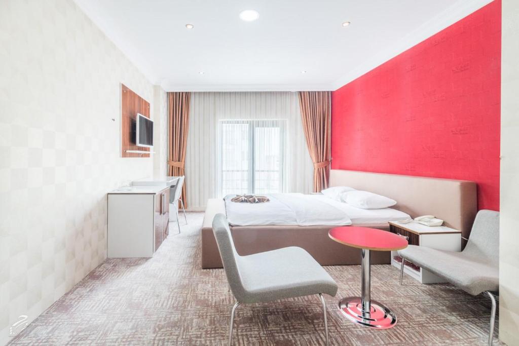 Habitación de hotel con cama y pared roja en Hotel Dosco en Van