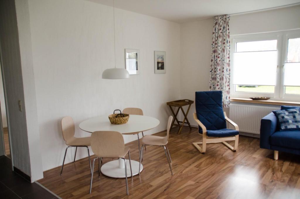 - un salon avec une table et des chaises dans l'établissement Ferienwohnung 1 Wildgans, à Sagard