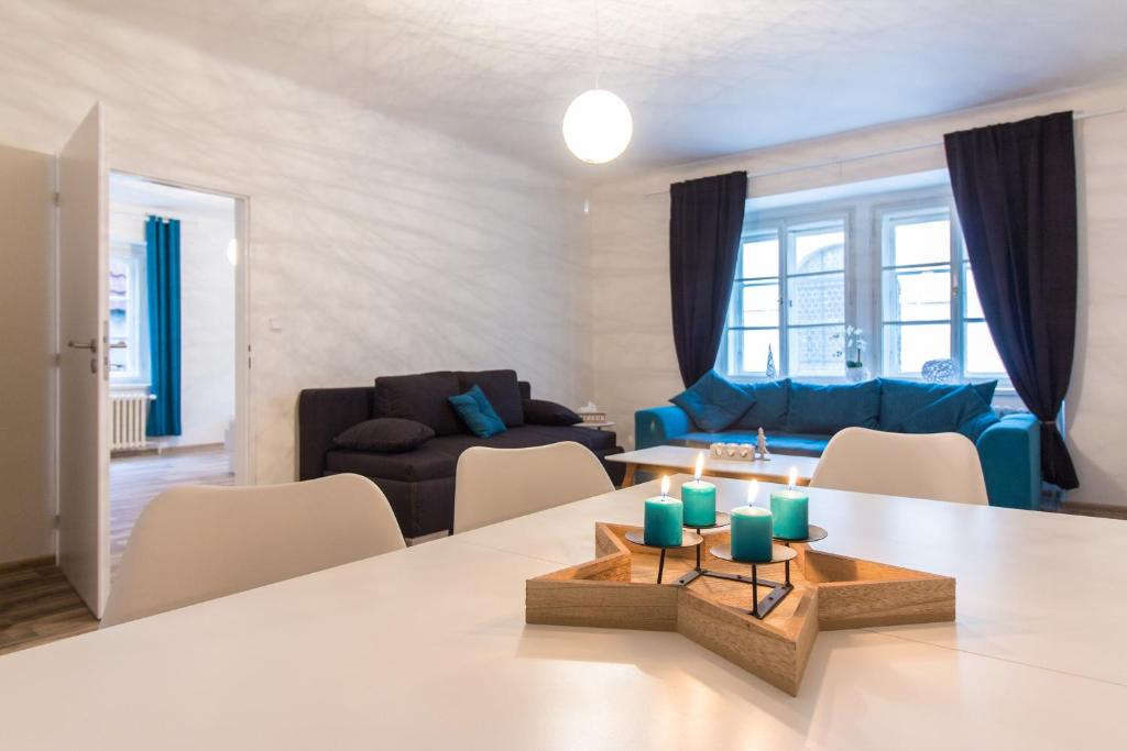 uma sala de estar com uma mesa e um sofá em Karlova Apartment em Praga