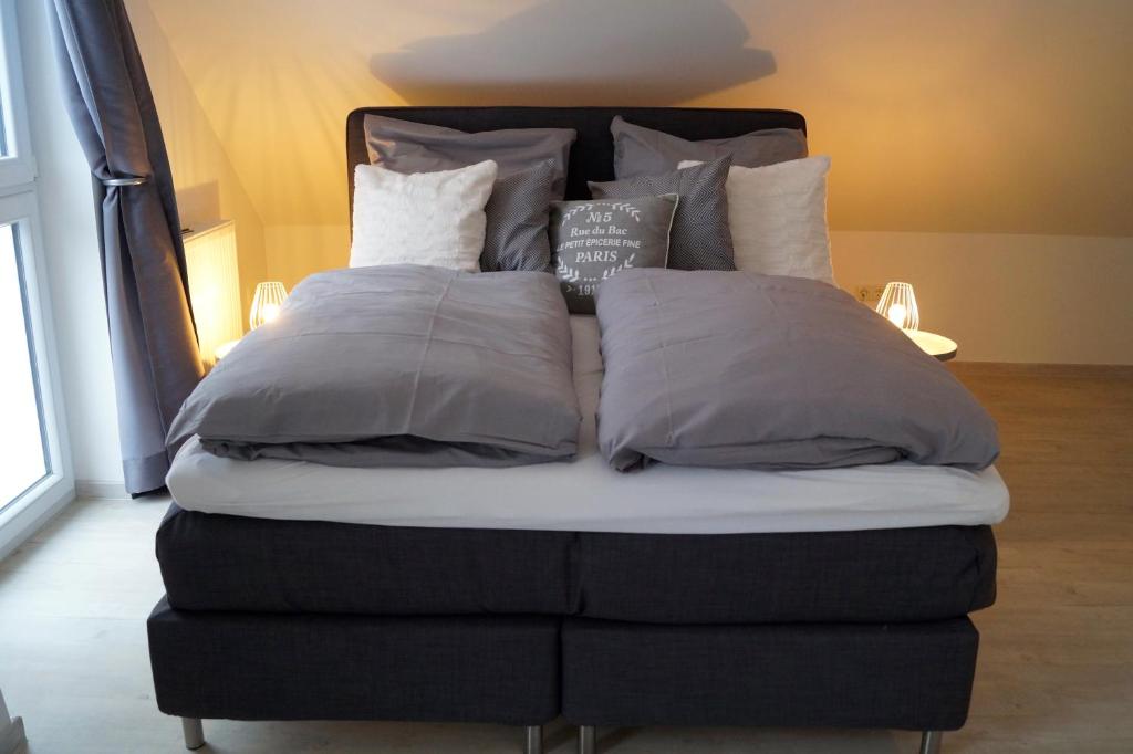 a bed with four pillows on top of it at Ferienhaus Eifel Charlotte in Dahlem