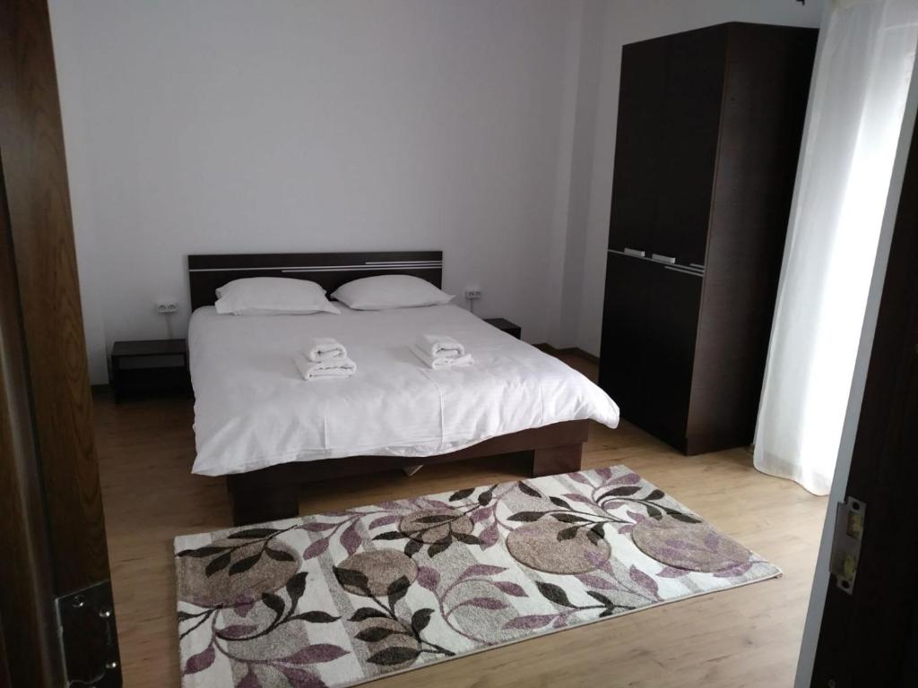 a bedroom with a bed and a rug on the floor at Alexys Residence 6 in Iaşi