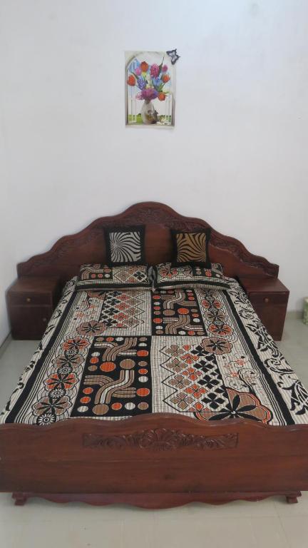 a bed with a blanket on top of it at City Bay House in Weligama