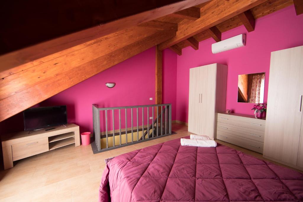CittanovaにあるALBAGIO'のピンクの壁のベッドルーム1室、ベッド1台が備わります。