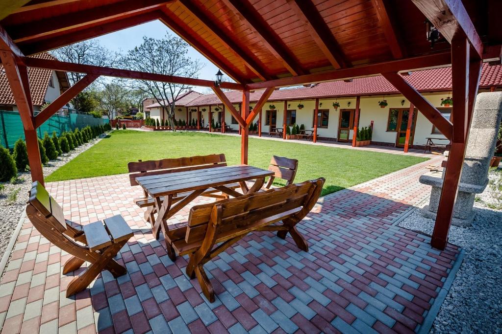 a picnic table and benches on a brick patio at Apartman Levandula in Veľký Meder