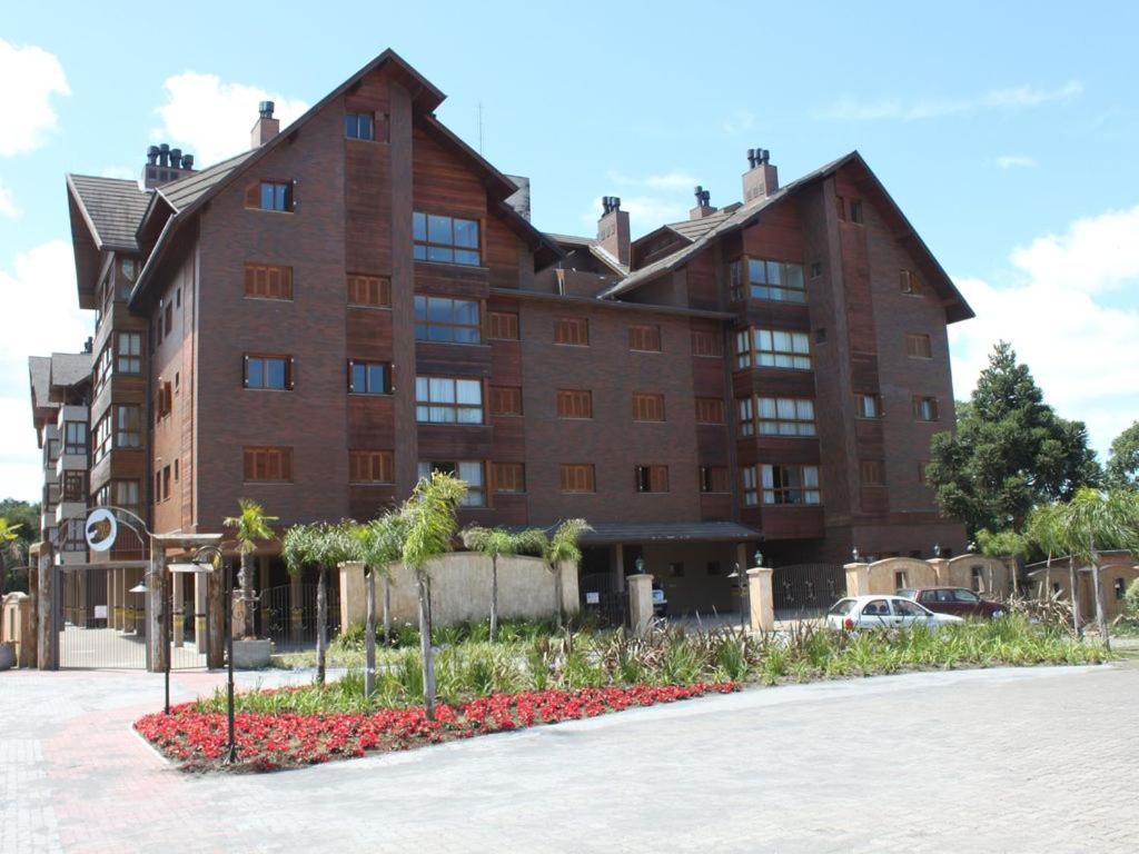 un gran edificio marrón con flores delante en Apto lindo e novo no centro Gramado, en Gramado