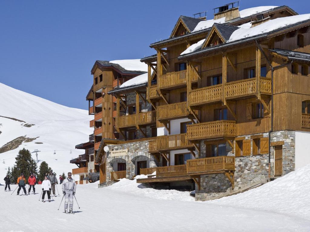 a group of people skiing in front of a ski lodge at Le Chalet des Cimes in Belle Plagne