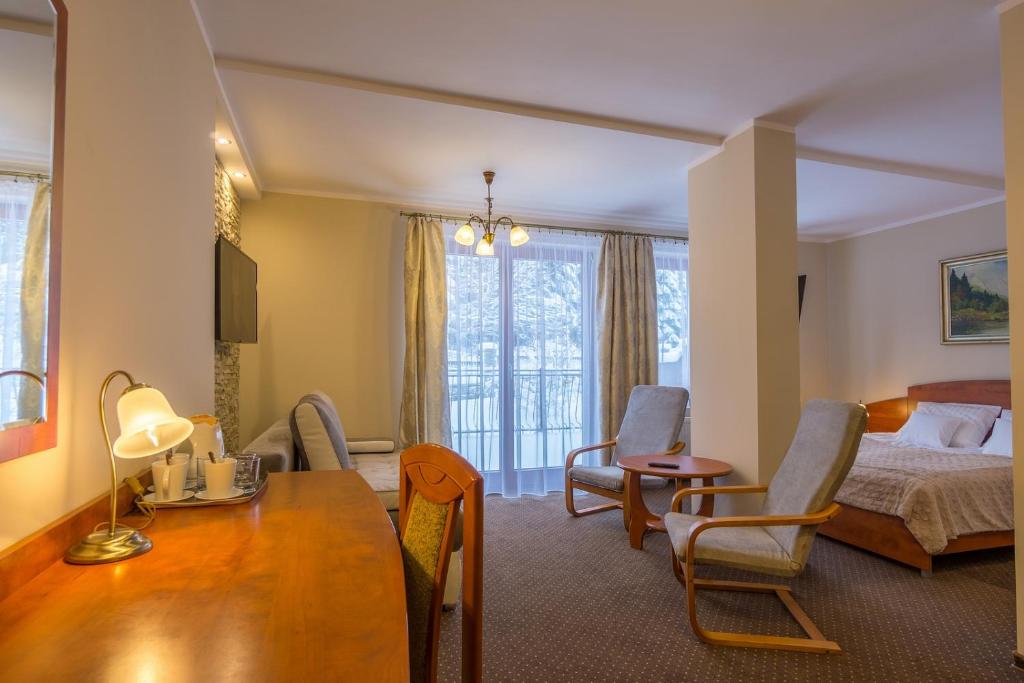 pokój hotelowy z łóżkiem, stołem i krzesłami w obiekcie Hotel Diament w Szklarskiej Porębie