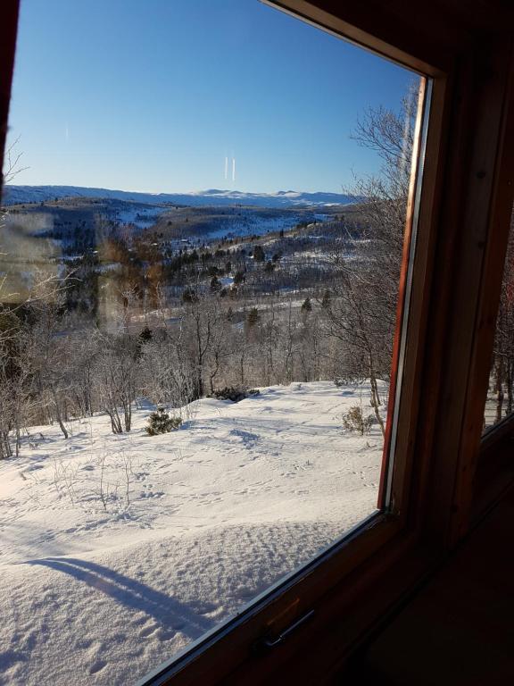 a view from a window of a snow covered field at Fjellbu Two-bedroom Cottage in Geilo