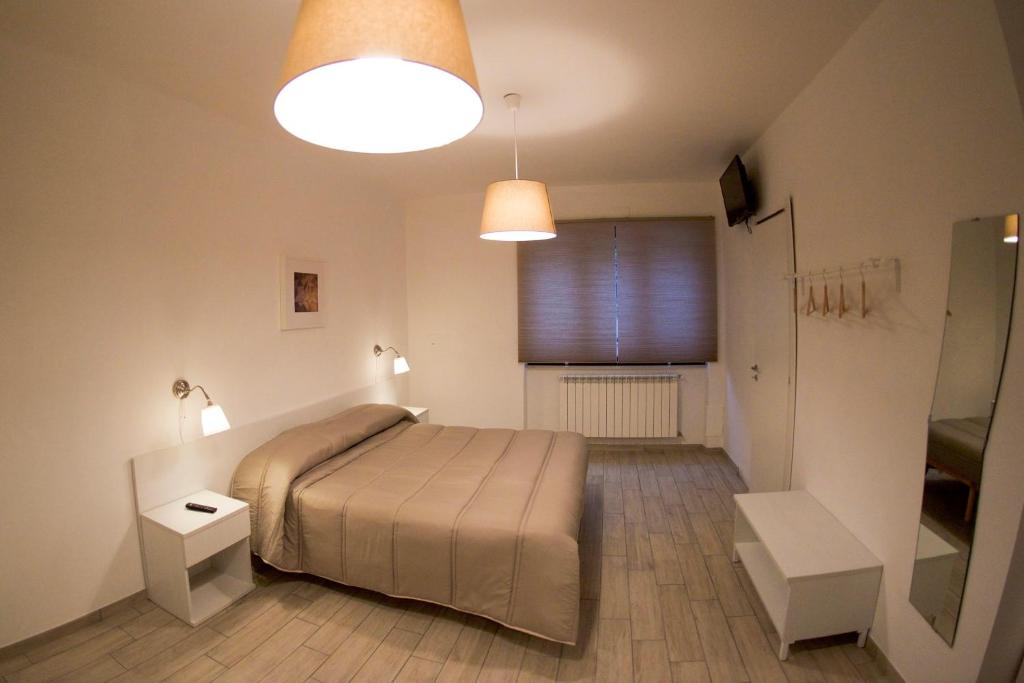 een slaapkamer met een bed, 2 verlichting en een raam bij Lenotti Bed and Breakfast in Campobasso