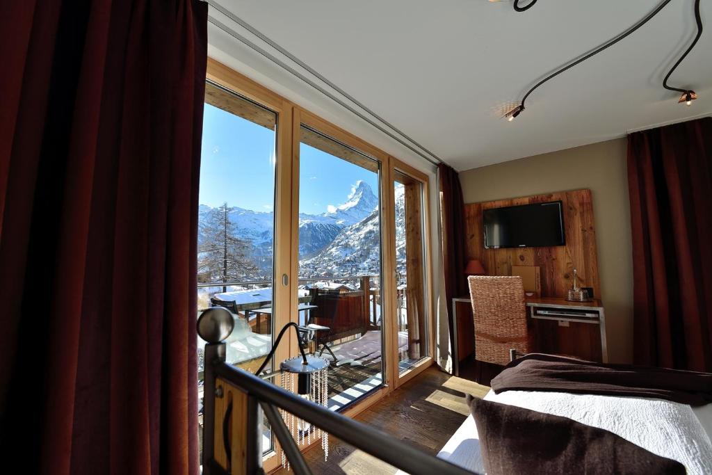 a bedroom with a balcony with a view of a mountain at Alpenlodge in Zermatt