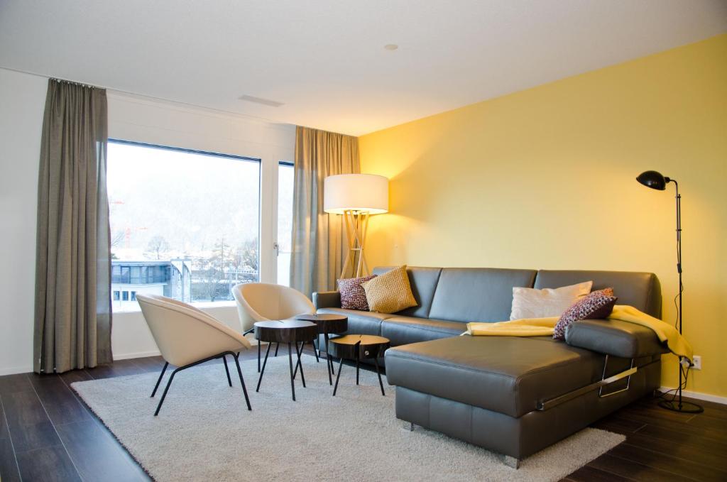 因特拉肯的住宿－Apartment Arnika - GriwaRent AG，客厅配有沙发和桌椅
