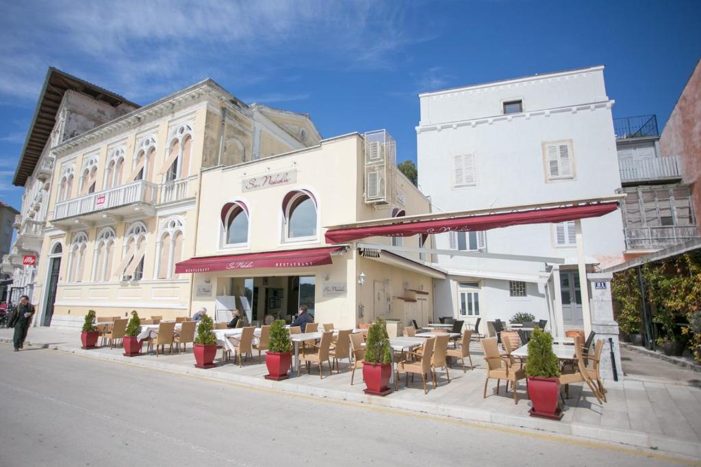 un edificio con mesas y sillas en una calle de la ciudad en Apartment Nikola, en Poreč