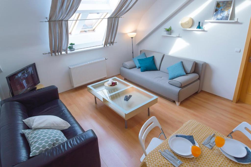 een woonkamer met een bank en een tafel bij Modern Apartments Opatovická in Praag