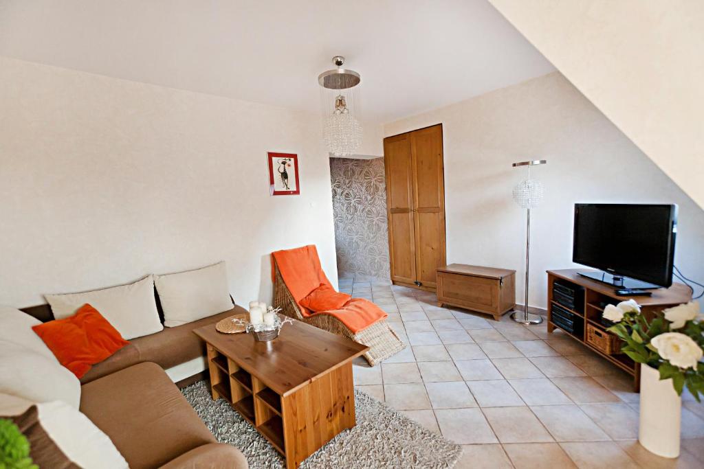 a living room with a couch and a tv at Apartamenty Sun & Snow Centrum in Zakopane