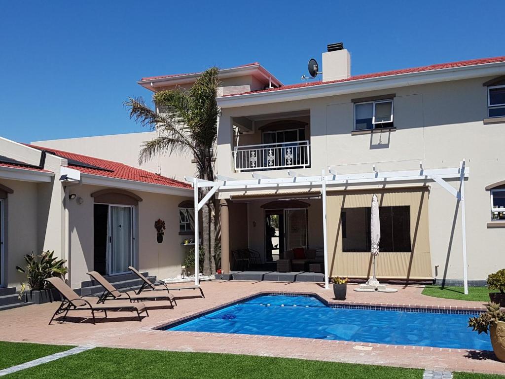 a villa with a swimming pool and a house at Carmel Huys in Cape Town