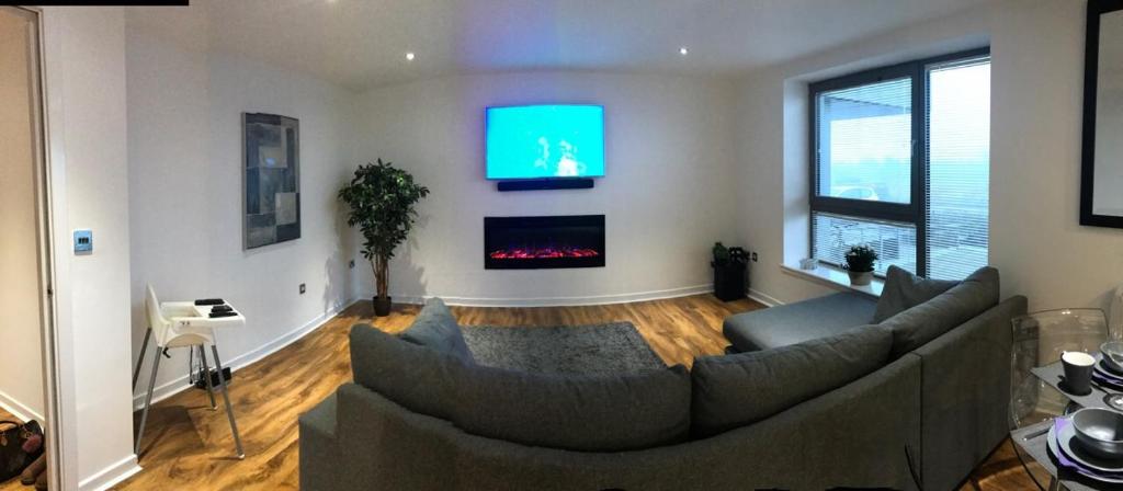 uma sala de estar com um sofá e uma televisão em Matysiak Apartment em Edimburgo