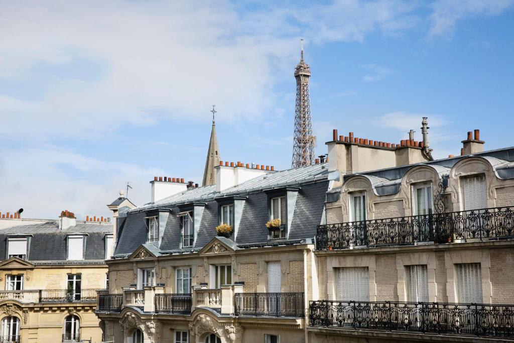 einen Blick auf ein Gebäude mit einem Turm im Hintergrund in der Unterkunft Europe Hotel Paris Eiffel in Paris